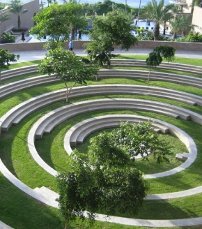 This is an aerial view of a beautifully designed amphitheater within Dosti West County, with concentric circles of seating surrounded by greenery, providing a communal outdoor space for events and gatherings in the Thane Balkum area.